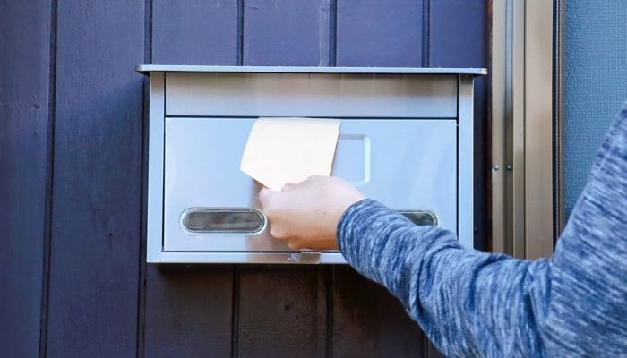 Hand wirft einen Brief in einen Briefkasten – Geschäftsadresse und Postservice bei CoWorking SchloHo