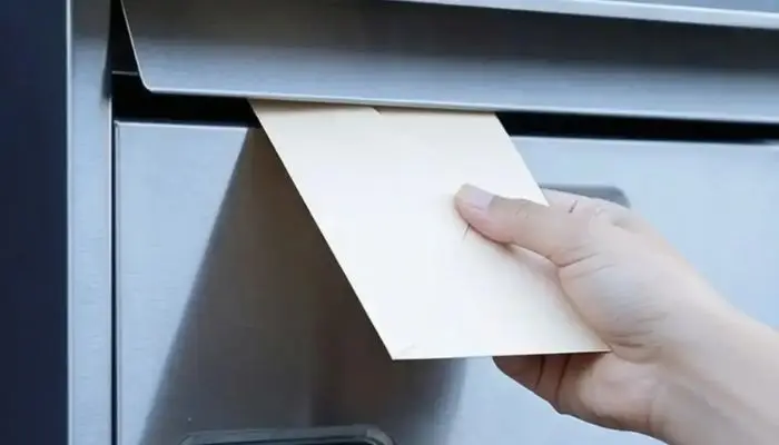 Post wird in einen Briefkasten eingeworfen – Postservice bei CoWorking SchloHo